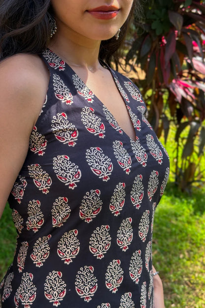 Woman wearing a sleeveless top with a paisley pattern in an outdoor setting