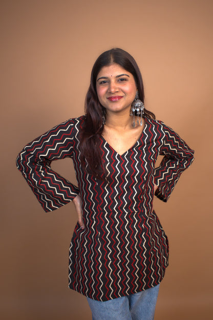 Woman wearing a zigzag patterned top against a background