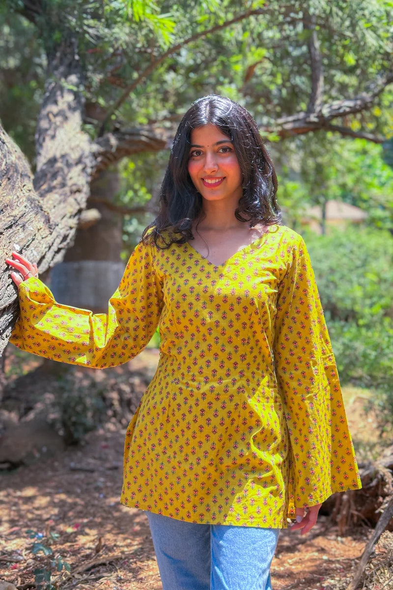 Woman wearing a jiva-yellow patterned top outdoors