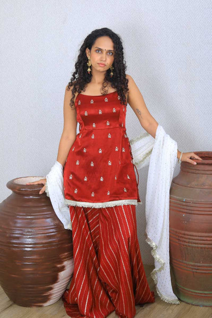 Girl wearing a traditional Maroon Palazzo Set with a white dupatta