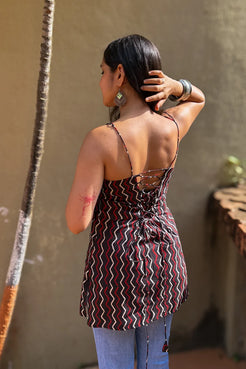 Woman wearing a zigzag patterned top with a neutral background