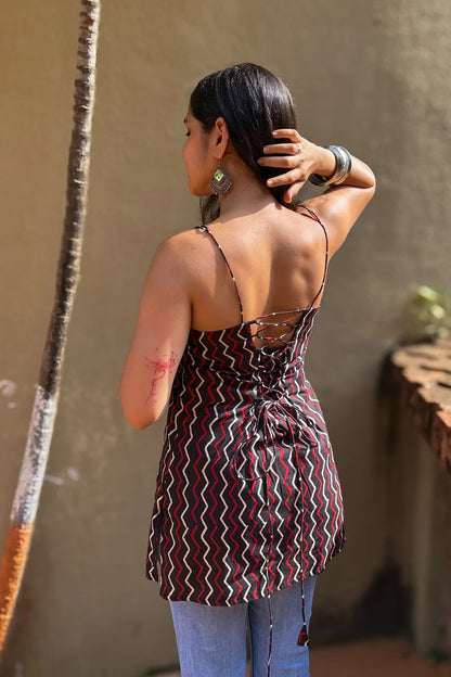 Woman wearing a zigzag patterned top with a neutral background