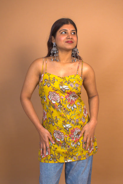 Woman wearing a jal-yellow floral top against a brown background