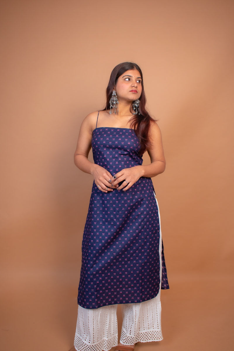 Woman wearing a jiva-blue dress with white lace hem on a brown background