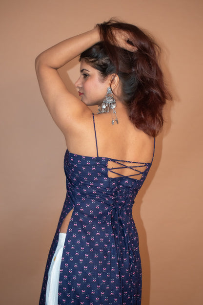 Woman wearing a jiva-blue patterned dress with a beige background