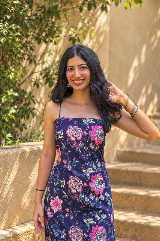 Woman wearing a jal-blue floral dress standing in a garden