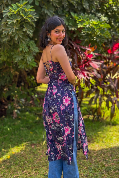 Woman wearing a jal-blue floral dress standing in a garden