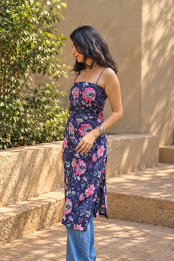 Woman wearing a jal-blue floral dress standing in a garden