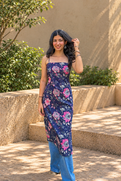 Woman wearing a jal-blue floral dress standing in a garden