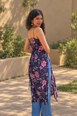Woman wearing a jal-blue floral dress standing in a garden