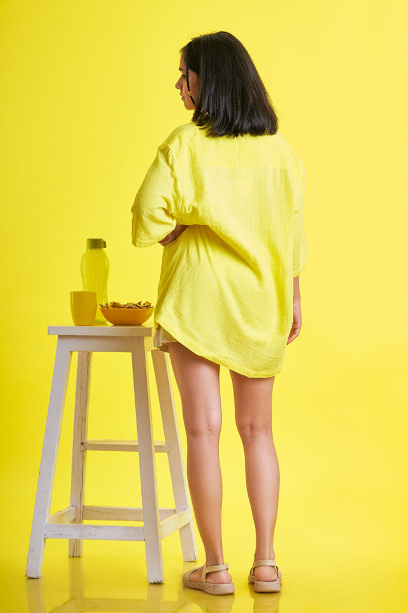 Girl wearing an oversized yellow unisex shirt from the back