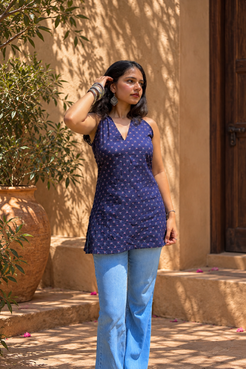 Jiva-blue dress with pink floral pattern worn by a person, standing outdoors.