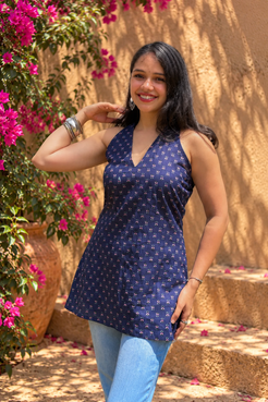 Jiva-blue dress with pink floral pattern worn by a person, standing outdoors.