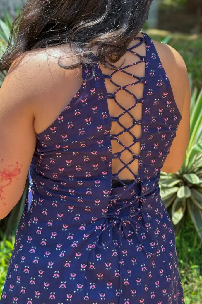 Jiva-blue dress with pink floral pattern worn by a person, standing outdoors.