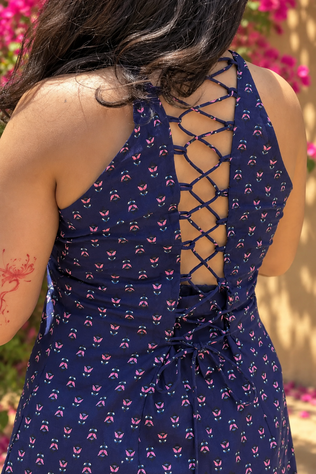 Jiva-blue dress with pink floral pattern worn by a person, standing outdoors.