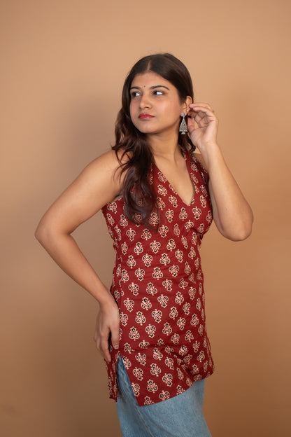 Woman wearing a butta red patterned top against a brown background